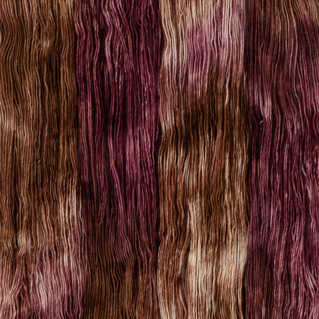 Sysleriget hand dyed yarn in single ply merino wool in the color Berry Crumble.